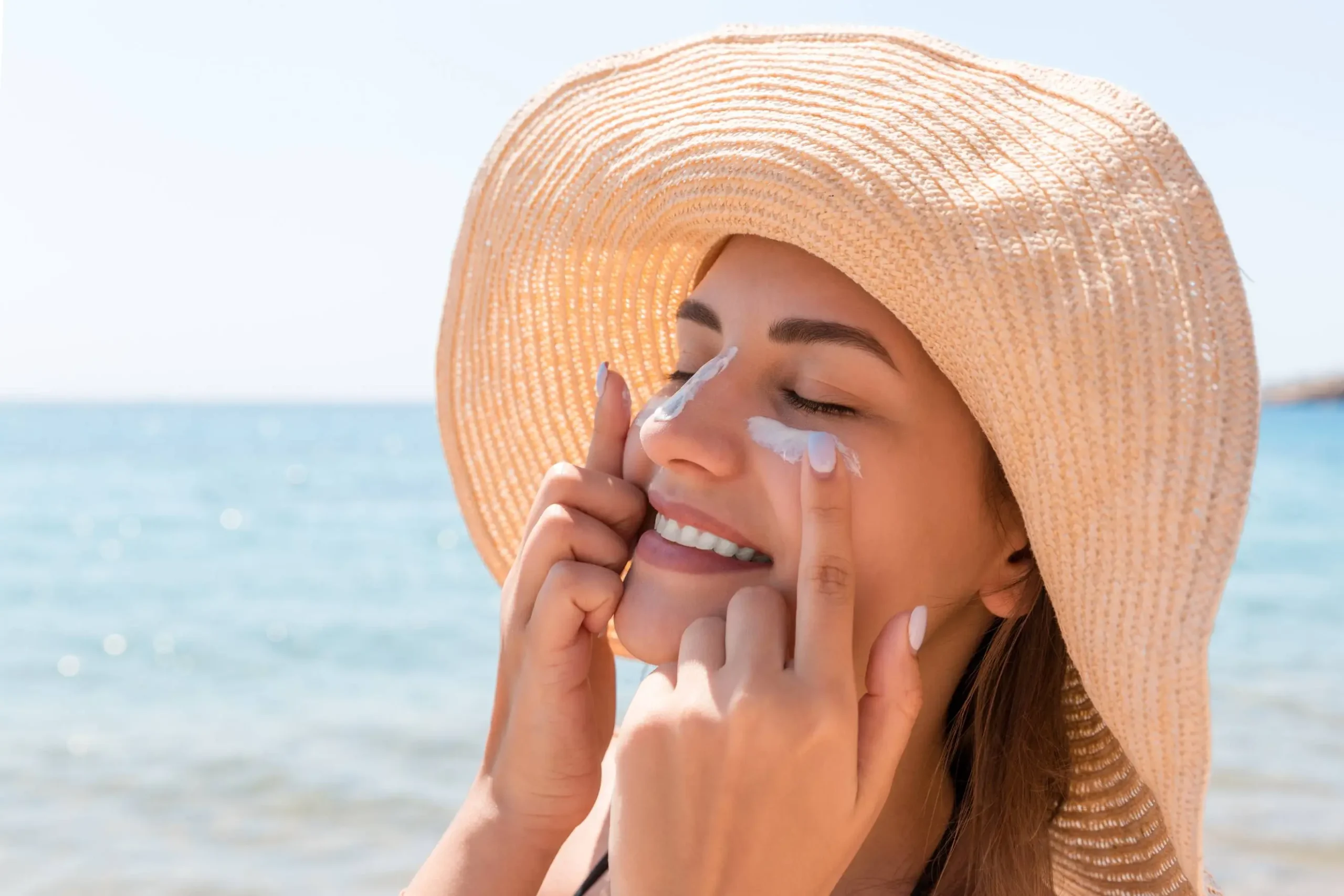 smiling woman hat is applying sunscreen her face indian style - Zicail Beauty smiling woman hat is applying sunscreen her face indian style - Sunscreen 101: How to Choose, Apply, and Reapply SPF