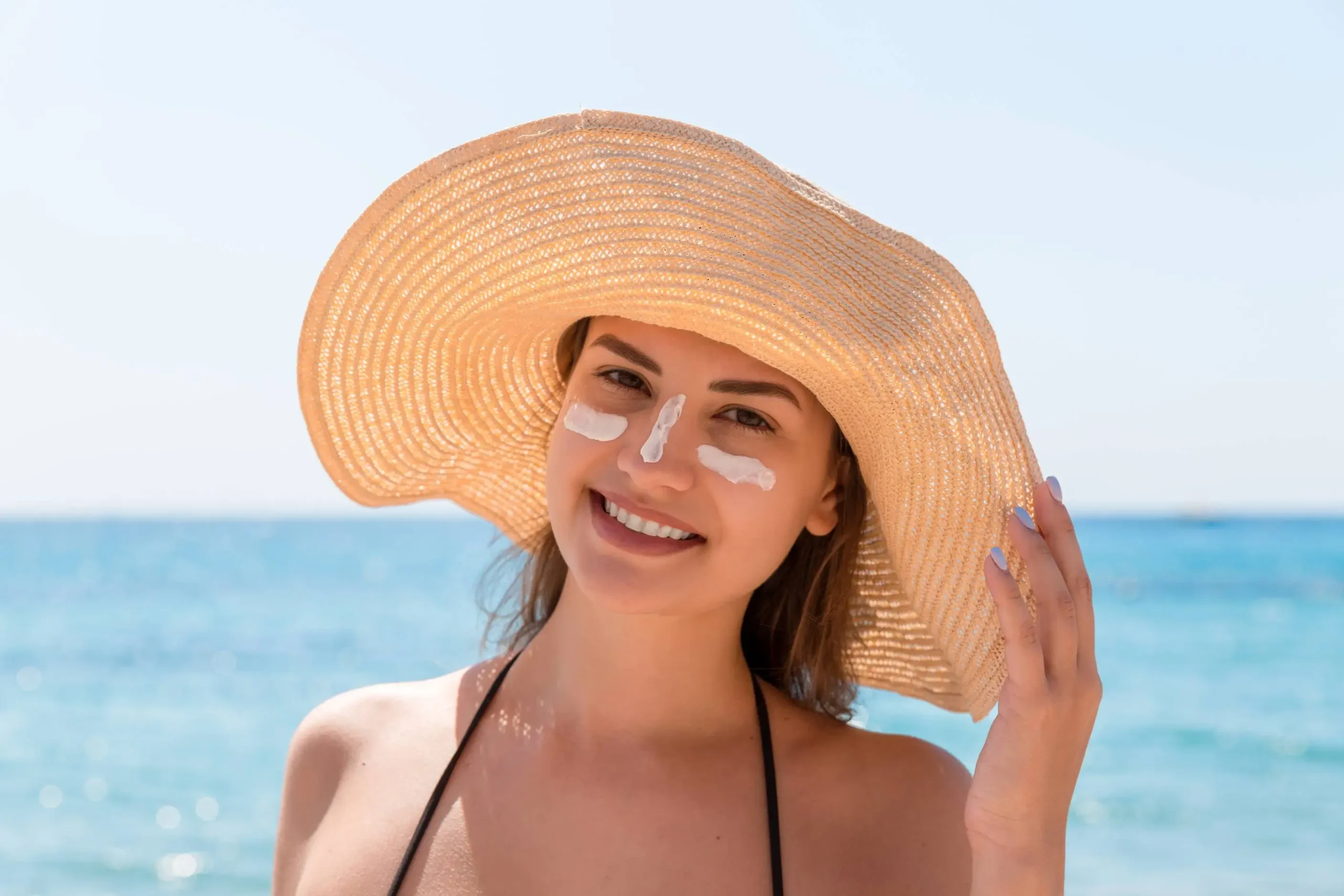 smiling woman hat is applying sunscreen her face indian style 1 - Zicail Beauty smiling woman hat is applying sunscreen her face indian style 1 - Does Sunscreen Expire? How to Tell If SPF Is Still Safe